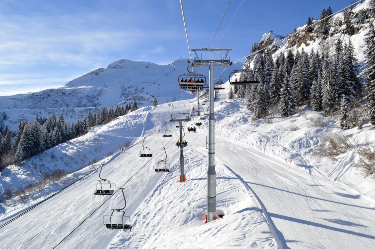 Chairlifts running up a groomed run at a ski resort